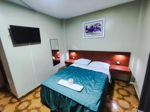 Habitación de hotel con cama y TV en Hostal Continental, en Nazca