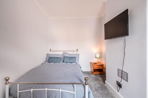 a bedroom with a bed and a flat screen tv at SuffStay in Ipswich