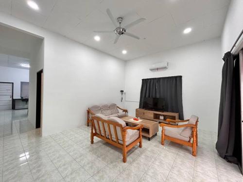 ein Wohnzimmer mit 2 Stühlen und einem TV in der Unterkunft Juzt Homestay Kpg Boyan in Taiping