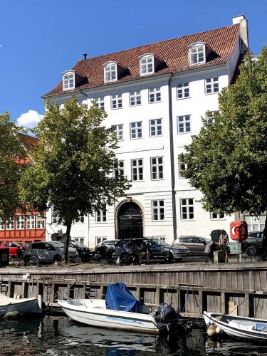 duży biały budynek z łodziami w wodzie w obiekcie Christianshavn Canalside Luxury Apartment w Kopenhadze