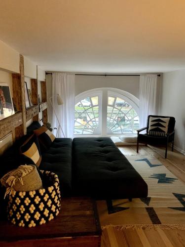 salon z czarną kanapą i oknem w obiekcie Christianshavn Canalside Luxury Apartment w Kopenhadze