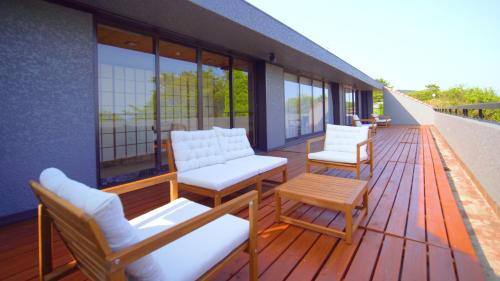 una terraza con sillas y mesas en un edificio en Alivio ATAMI en Atami