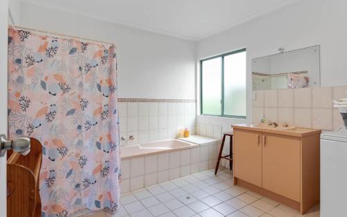 uma casa de banho com uma banheira e uma cortina de chuveiro em Great Family Holiday House in Central Location em Victor Harbor