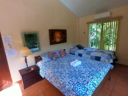a bedroom with a bed and a lamp and a window at Yethan house in Uvita