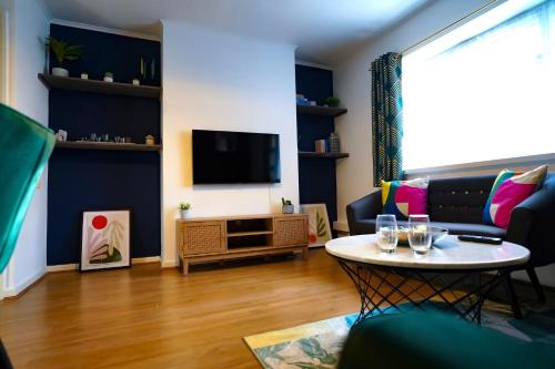 a living room with a table and a tv at Enfield North London 3BR Apartment in London