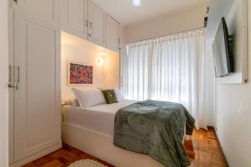 Vinicius de Moraes Ipanema Apartment في ريو دي جانيرو: غرفة نوم صغيرة بها سرير ونافذة