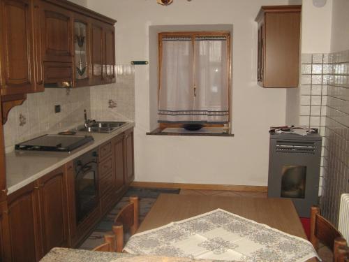 a kitchen with a table and a sink and a window at Casa Danoli in Canale San Bovo