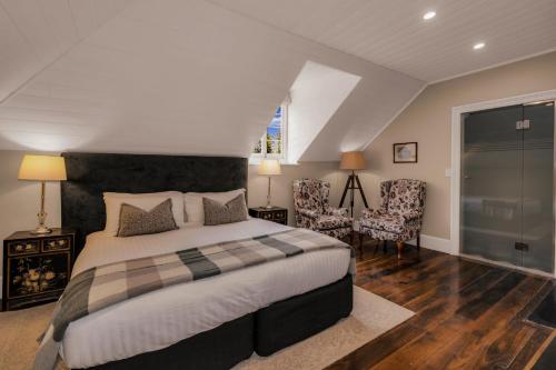 a bedroom with a large bed and two chairs at Quamby Estate in Hagley