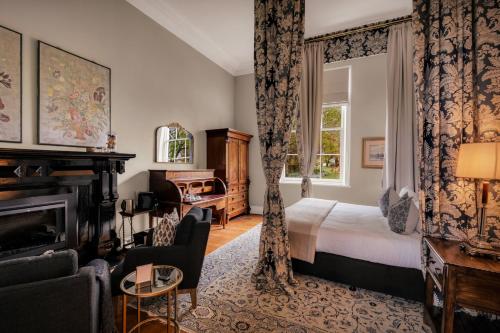Quamby Estate في Hagley: غرفة فندقية بها سرير وموقد