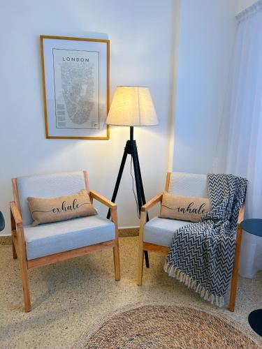 een woonkamer met 2 stoelen en een lamp bij Alquiler temporario in Bahía Blanca