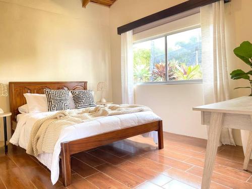 1 dormitorio con cama con almohadas y ventana en Astonishing view at Poás Volcano slopes: Casa Lili, en Grecia