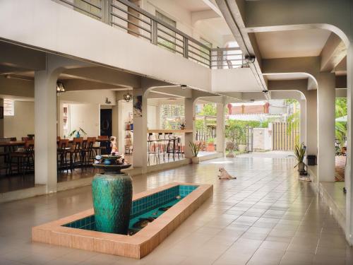 - un hall avec une piscine au milieu d'un bâtiment dans l'établissement Chiangmai Inn Guest House, à Chiang Mai