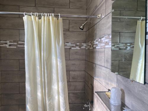a shower with a shower curtain in a bathroom at RANGER MOTEL in Cheyenne