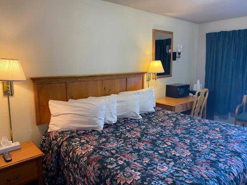 a hotel room with a bed with white pillows at RANGER MOTEL in Cheyenne