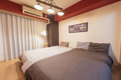 a bedroom with two beds and a window at MELL-THEATE - Nibiironokaze - in Osaka