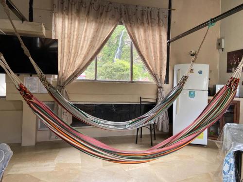 a hammock in a living room with a window at APARTAMENTO ESTUDIO - COMPLETO Y MUY BIEN UBICADO in Baños