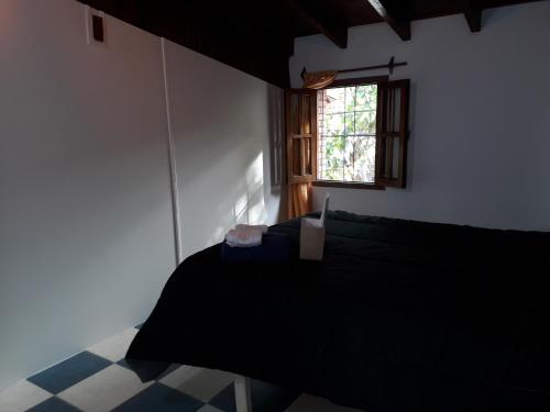 1 dormitorio con cama negra y ventana en Habitacion privada en hermosa casa centrica de Ciudad en Mendoza