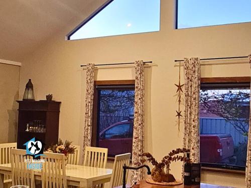 a dining room with a table and some windows at A Beautiful Property, Walking Distance to the Beach in Esperance WA! in Esperance