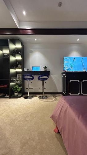 a room with two bar stools and a tv at Mango Hotel - Ha Noi Railway station in Hanoi