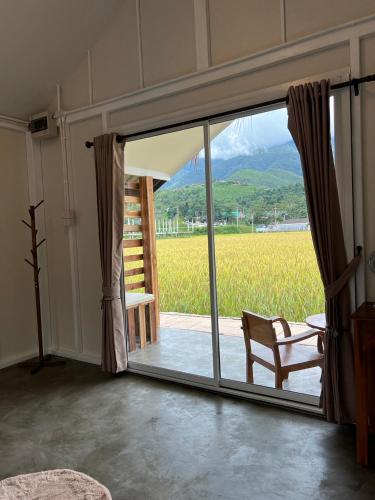 a room with a sliding glass door with a chair at สะปันดีวิว Sapan Dee View บ่อเกลือ น่าน in Ban Huai Ti