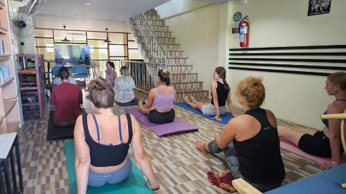 un grupo de personas sentadas en una clase de yoga en Phangan Barsay Hostel, en Thong Sala