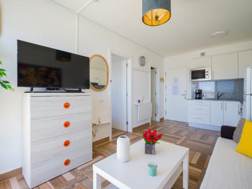a living room with a white dresser with a tv on it at Incredible Sunsets in Puerto Rico de Gran Canaria