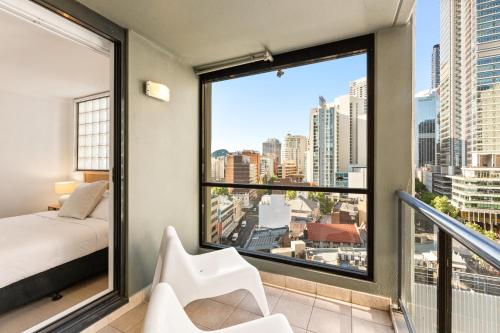 a bedroom with a bed and a view of a city at City Skyline Views CBD Apartment - 1602 in Sydney