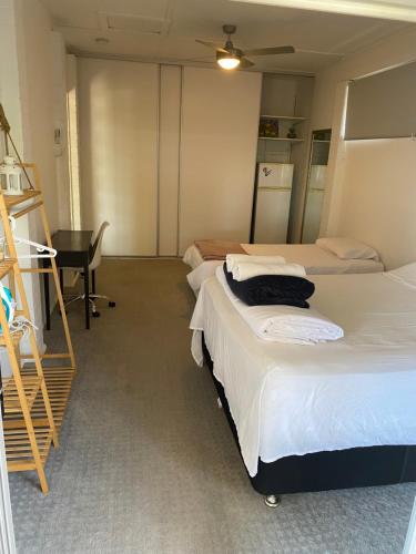 2 letti in una camera con scrivania e una camera con di Room in a Family home a Gold Coast