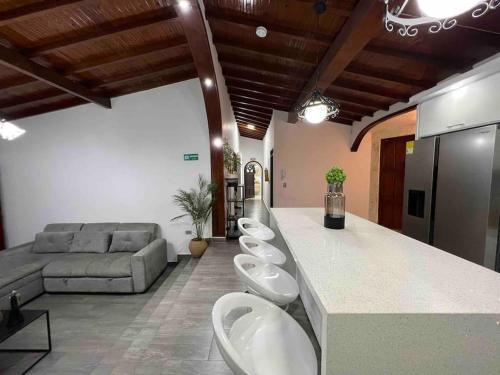 a bathroom with three sinks and a counter with a couch at Apt Palos Altos Poblado, a distancia caminando de restaurantes in Medellín