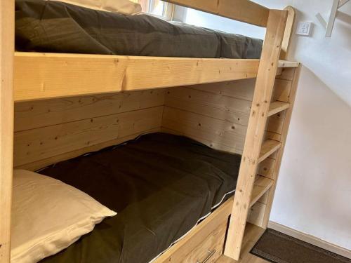 ein hölzernes Etagenbett in einem Zimmer mit einer Leiter in der Unterkunft Charmant Studio 4p avec Terrasse Sud – Proche Pistes & Commerces – Alpe d'Huez - FR-1-405-339 in Huez