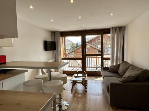 un salon avec un canapé et une table dans l'établissement Charmant Studio 4p avec Terrasse Sud – Proche Pistes & Commerces – Alpe d'Huez - FR-1-405-339, à Huez