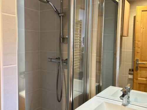 eine Dusche mit Glastür neben einem Waschbecken in der Unterkunft Charmant Studio 4p avec Terrasse Sud – Proche Pistes & Commerces – Alpe d'Huez - FR-1-405-339 in Huez