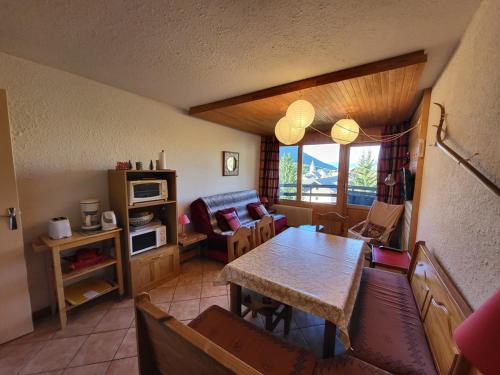 un salon avec une table et un canapé dans l'établissement Appartement cosy 2 pièces, 6 pers, balcon, Montgenèvre - FR-1-266-217, à Montgenèvre