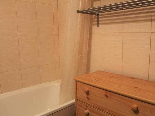 a bathroom with a tub and a shower curtain at Appartement Vars, 1 pièce, 4 personnes - FR-1-330B-211 in Vars