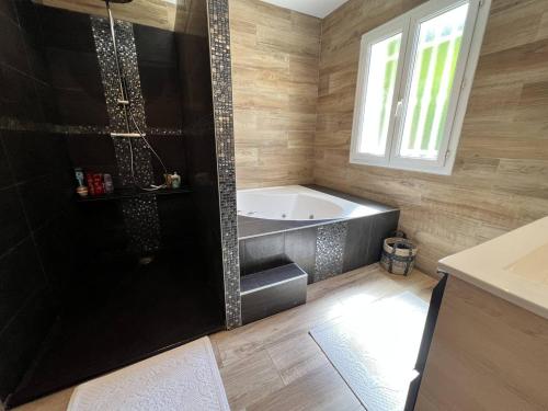ein Bad mit einer Badewanne und einem Fenster in der Unterkunft Villa La Croix-Valmer, 5 pièces, 8 personnes - FR-1-726-32 in La Croix-Valmer