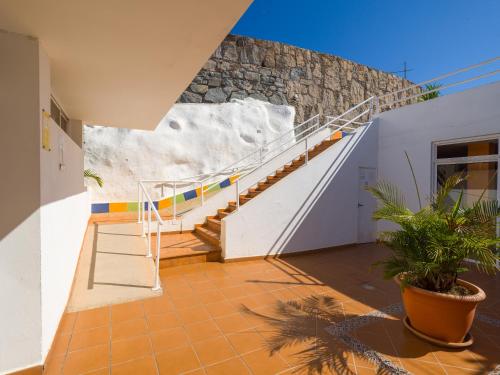 a house with a staircase and a stone wall at Incredible Sunsets in Puerto Rico de Gran Canaria