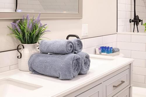 a pile of towels sitting on a counter in a bathroom at Renovated & Sophisticated Home Near Beach & Shops! in Barnstable