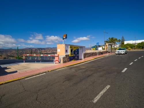 a car parked at a gas station on a road at Incredible Sunsets in Puerto Rico de Gran Canaria