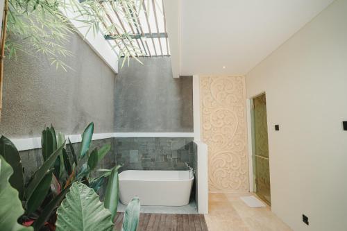 a bathroom with a bath tub and plants at Villa Bulan Bali in Jimbaran