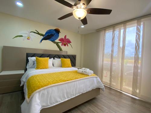 a bedroom with a bed with a bird on the wall at Finca La Perla in Armenia