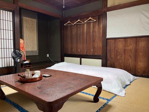 um quarto com uma cama e uma mesa de madeira em OSHI-KIKUYABO Mt-Fuji Historic Inn em Fujiyoshida