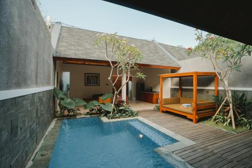 a house with a swimming pool in front of a house at Villa Bulan Bali in Jimbaran