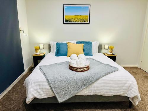 a bedroom with a bed with blue and yellow pillows at Ocean Breeze Family Getaway - Short drive to Beach & Adventure Park in Ocean Grove
