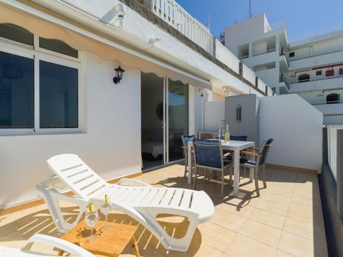 a patio with chairs and a table on a balcony at Incredible Sunsets in Puerto Rico de Gran Canaria