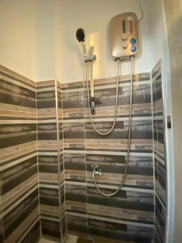 a shower in a bathroom with a glass door at Althea Apartelle in Moalboal