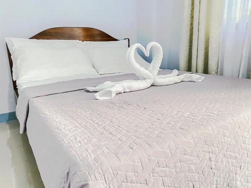 a bed with two swans made out of towels at Althea Apartelle in Moalboal