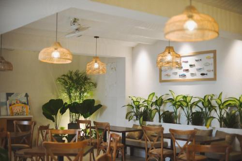 Phuong Nam Hotel An Giang في لونج زوين: غرفة طعام مزودة بالطاولات والكراسي والنباتات الفخارية