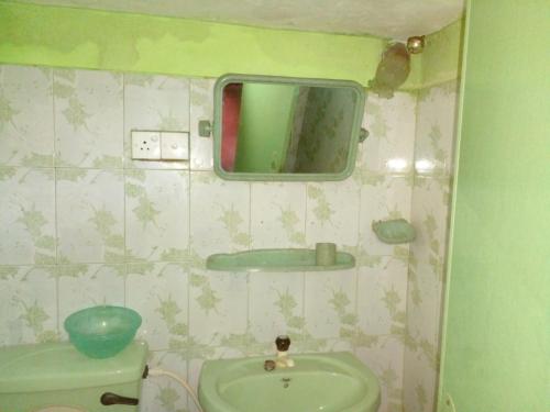 a small bathroom with a sink and a mirror at Pradeepa house in Unawatuna