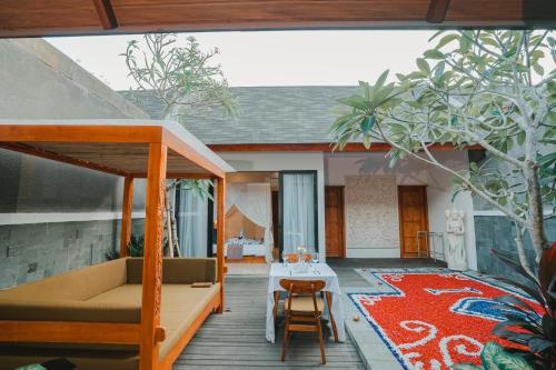a patio with a couch and a table and a rug at Villa Bulan Bali in Jimbaran