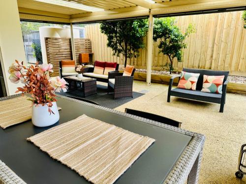 a screened in patio with a table and chairs at Ocean Breeze Family Getaway - Short drive to Beach, Wineries, Kids Golf & Adventure Park in Ocean Grove